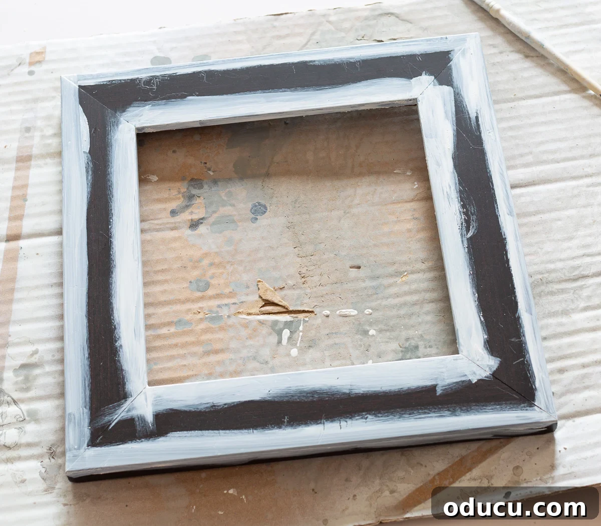 Instructions to paint the inside and outside edges of a photo frame for a clean finish during upcycling.