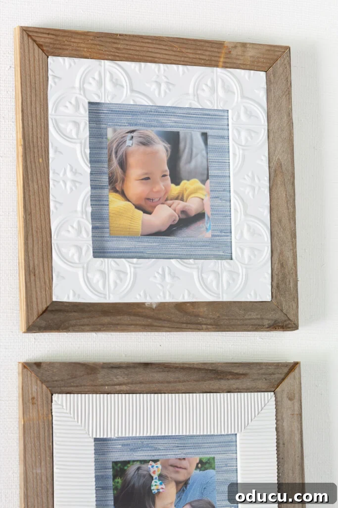 What to do with thrift store frames. An upcycled picture frame featuring painted vintage tin adhesive tile, scrap wood framing, and a wallpaper mat, displayed as part of a wall art collection.