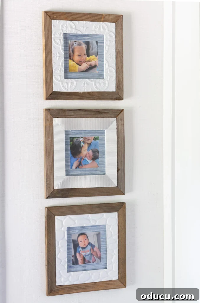 A set of 3 thrift store frames beautifully upcycled with scraps of wood, adhesive tile, and wallpaper, creating a cohesive and personalized home decor display.