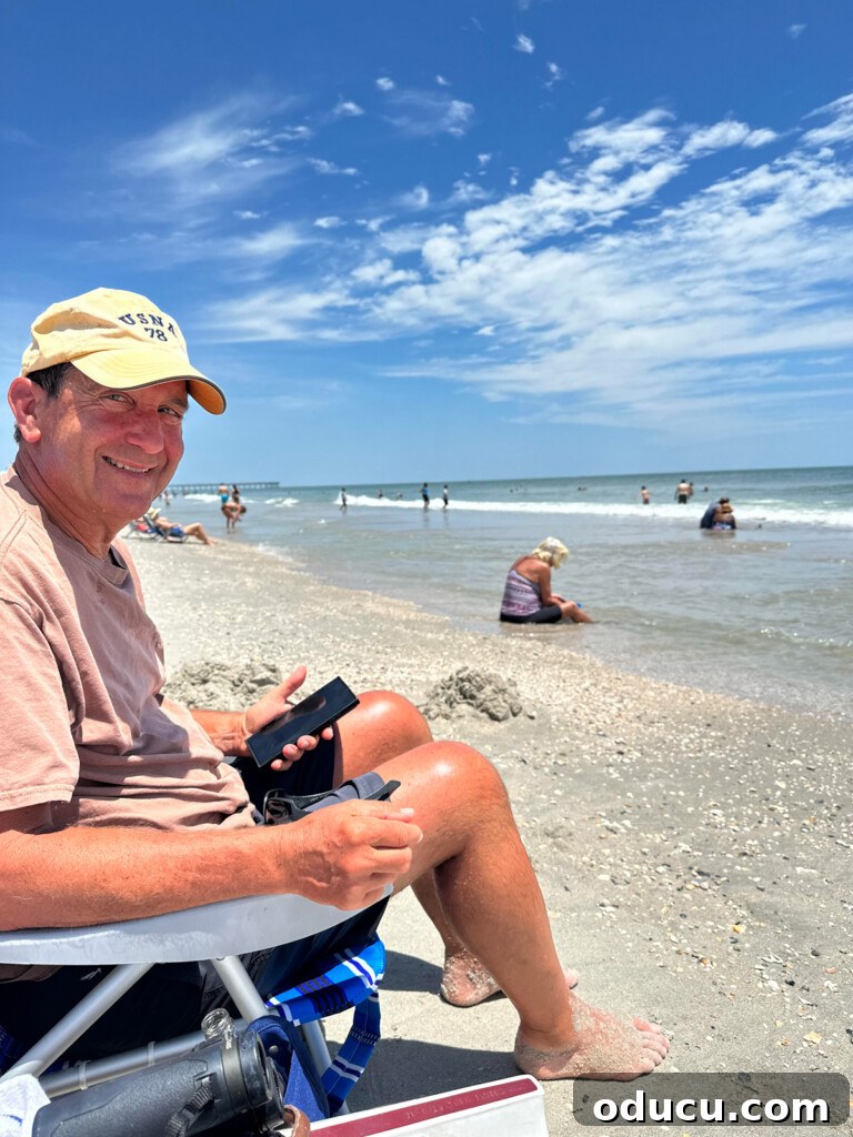 Style Finds 152 3 Ed sitting on a serene beach, enjoying the tranquil ocean view
