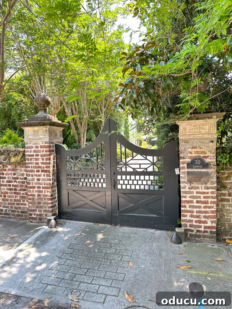 Ornate wood driveway door flanked by brick square columns.