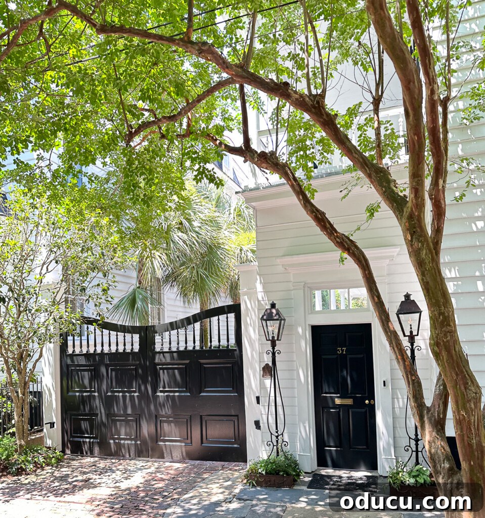 Ornate wood driveway doors painted black on a white house.