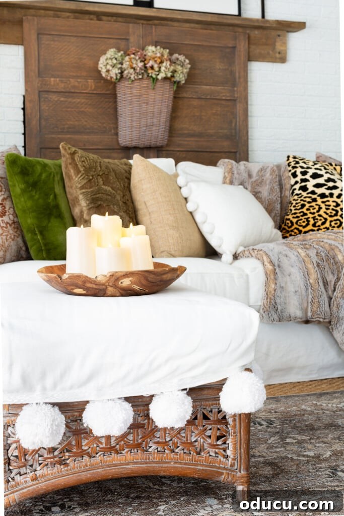 Creating a Cozy Fall Living Room Sanctuary 2 Large wood bowl on ottoman filled with battery operated off-white pillar candles in a living room.