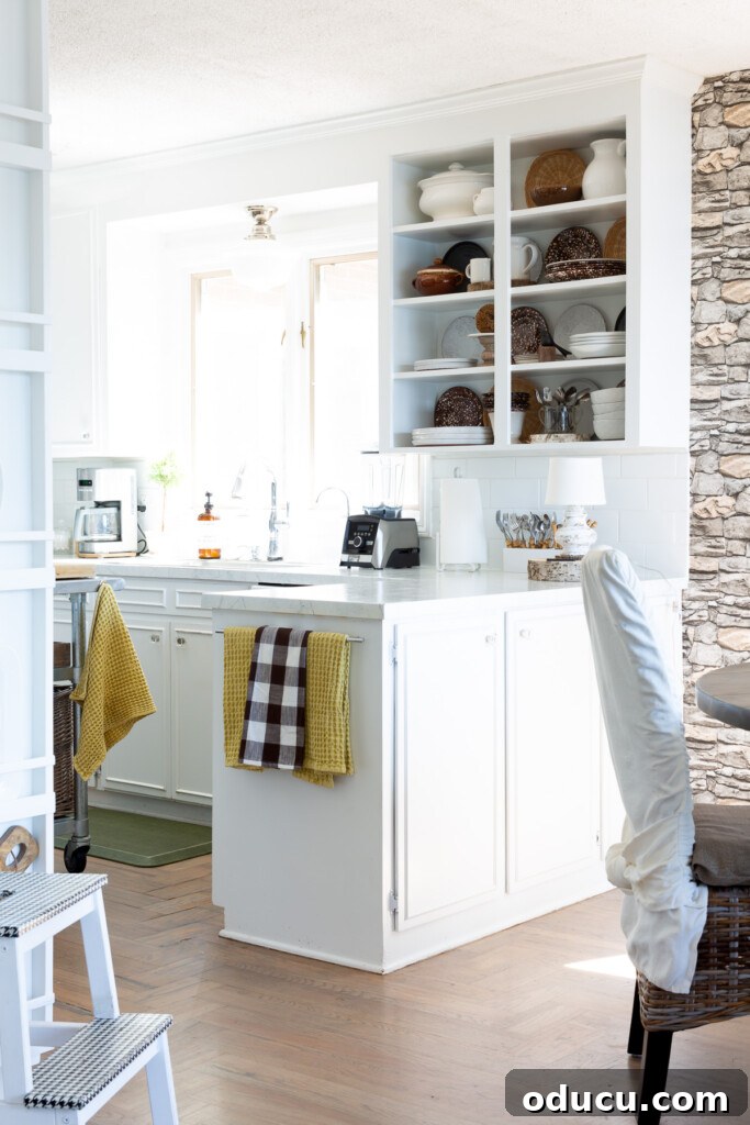 Mutfağımda Sonbahar Esintileri: Büyük Bir Yenilik Geldi! 11 white kitchen that is decorated in a simple way for fall uses browns mixed with white and yellow.