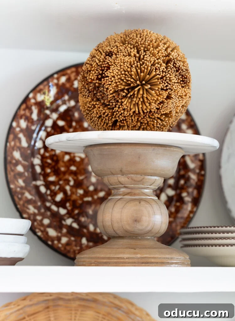 Mutfağımda Sonbahar Esintileri: Büyük Bir Yenilik Geldi! 16 A small wood pedestal with a decorative fall colored orb on am open shelf in a kitchen.