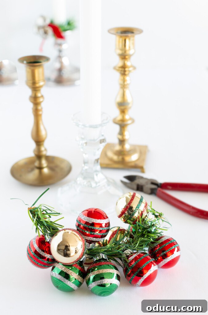 Simple Steps to Gorgeous Christmas Taper Candle Rings 7 Close-up view demonstrating the creation of a holiday taper candle ring using an array of miniature Christmas ornaments in festive colors.
