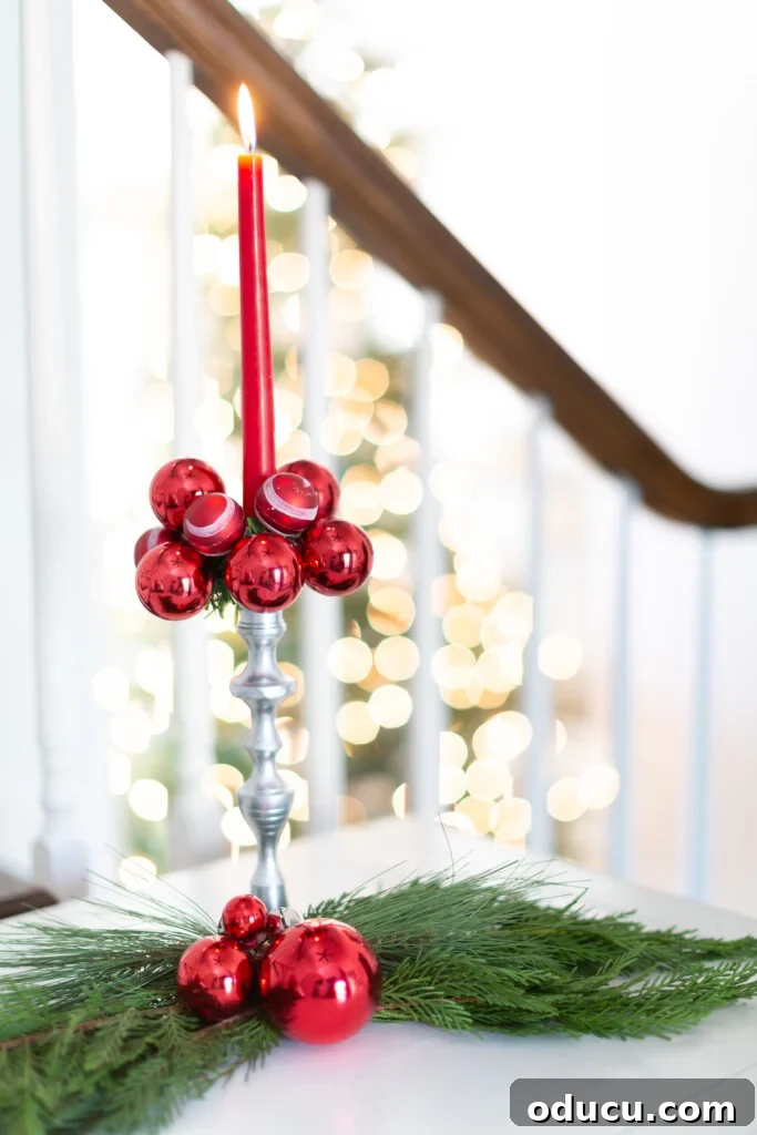 Simple Steps to Gorgeous Christmas Taper Candle Rings 10 A festive red taper candle set in a silver holder, enhanced by a striking Christmas candle ring crafted from matching red ball ornaments.