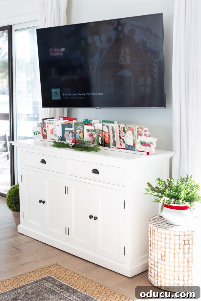 Showcase Your Holiday Cards: DIY Mantel & Table Display 15 DIY Christmas card stand elegantly positioned on a sideboard beneath a wall-mounted TV.