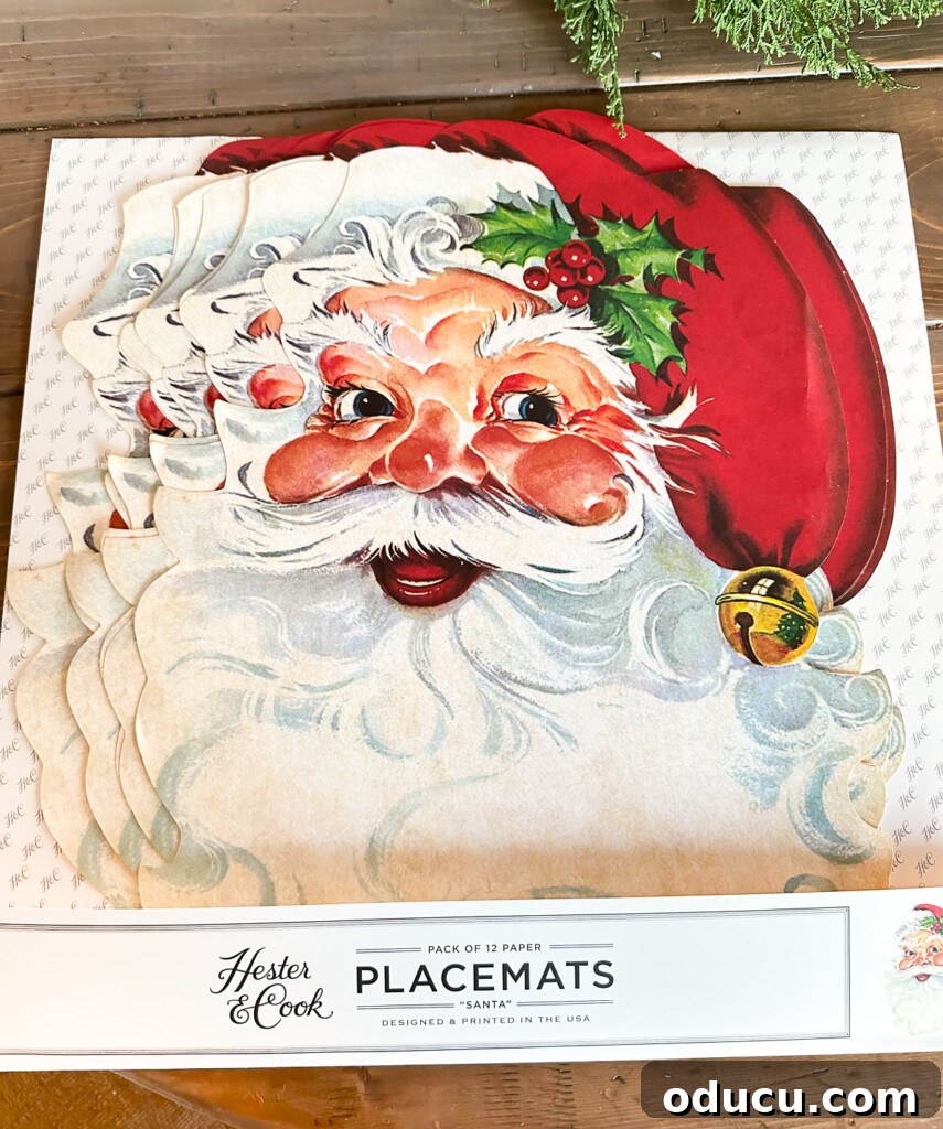Joyful and Merry Christmas Dinner Table 3 Hester & Cook Pack of 12 Face of Santa paper placemats, showcasing the intricate vintage design perfect for kid-friendly Christmas table decorations.