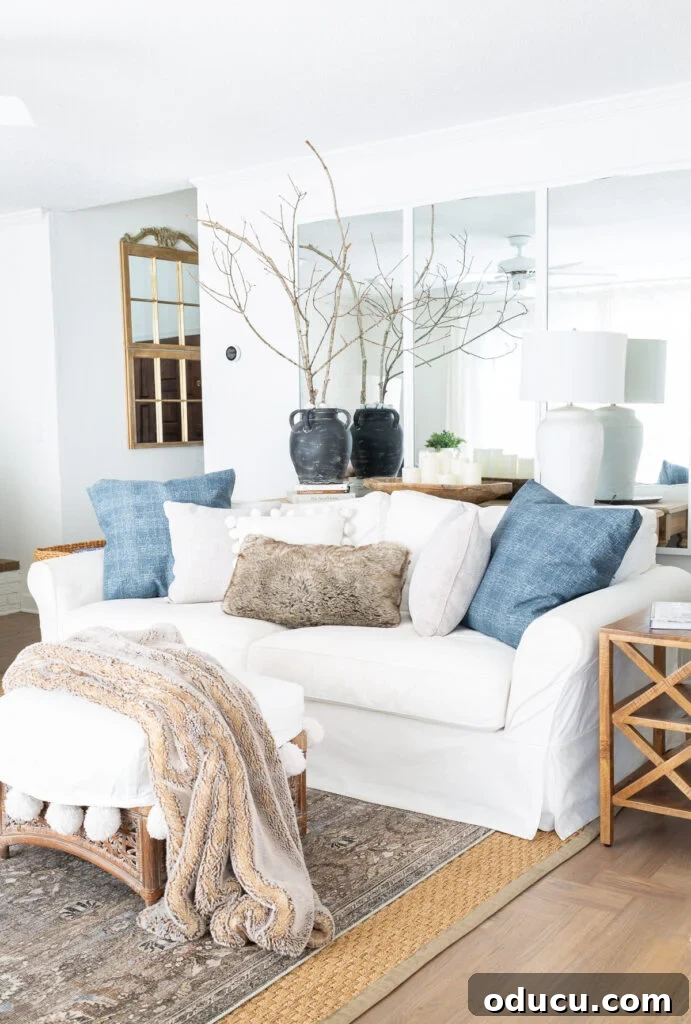 Effortless Winter Decor 6 Elegant blue and white living room, showcasing a mix of decorative pillows, fur throws, and carefully placed blue accents for a sophisticated winter decor.