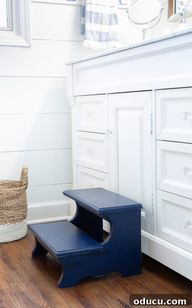 The Unsung Hero Your Home's Must-Have Small Furniture 5 After photo of a Thrift store wood step stool painted with Navy blue chalk paint. Placed in front of a white bathroom vanity.