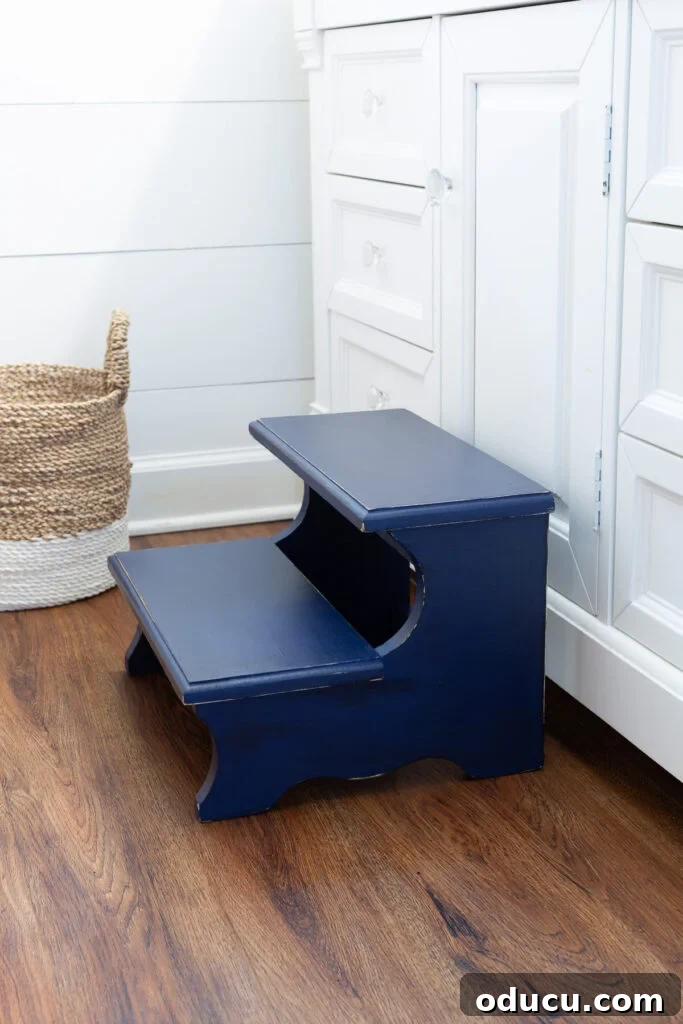 The Unsung Hero Your Home's Must-Have Small Furniture 6 After photo of a Thrift store wood step stool painted with Navy blue chalk paint. Placed in front of a white bathroom vanity.