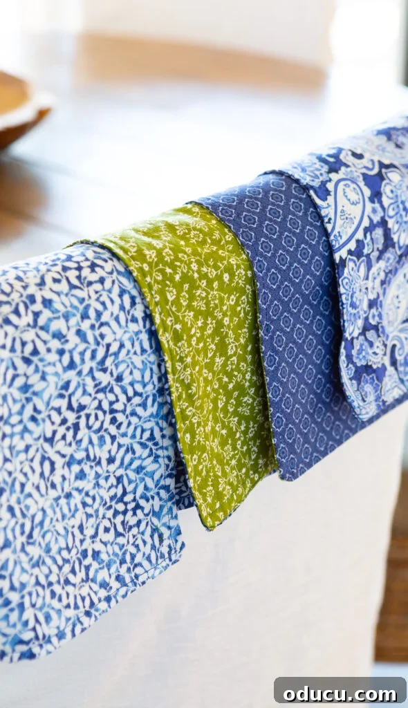 Whip Up Wonderful Napkins: A Simple Guide to Colorful Table Decor 2 4 two-ply cloth napkins hanging over the back of a dining chair, showcasing their reversible patterns.