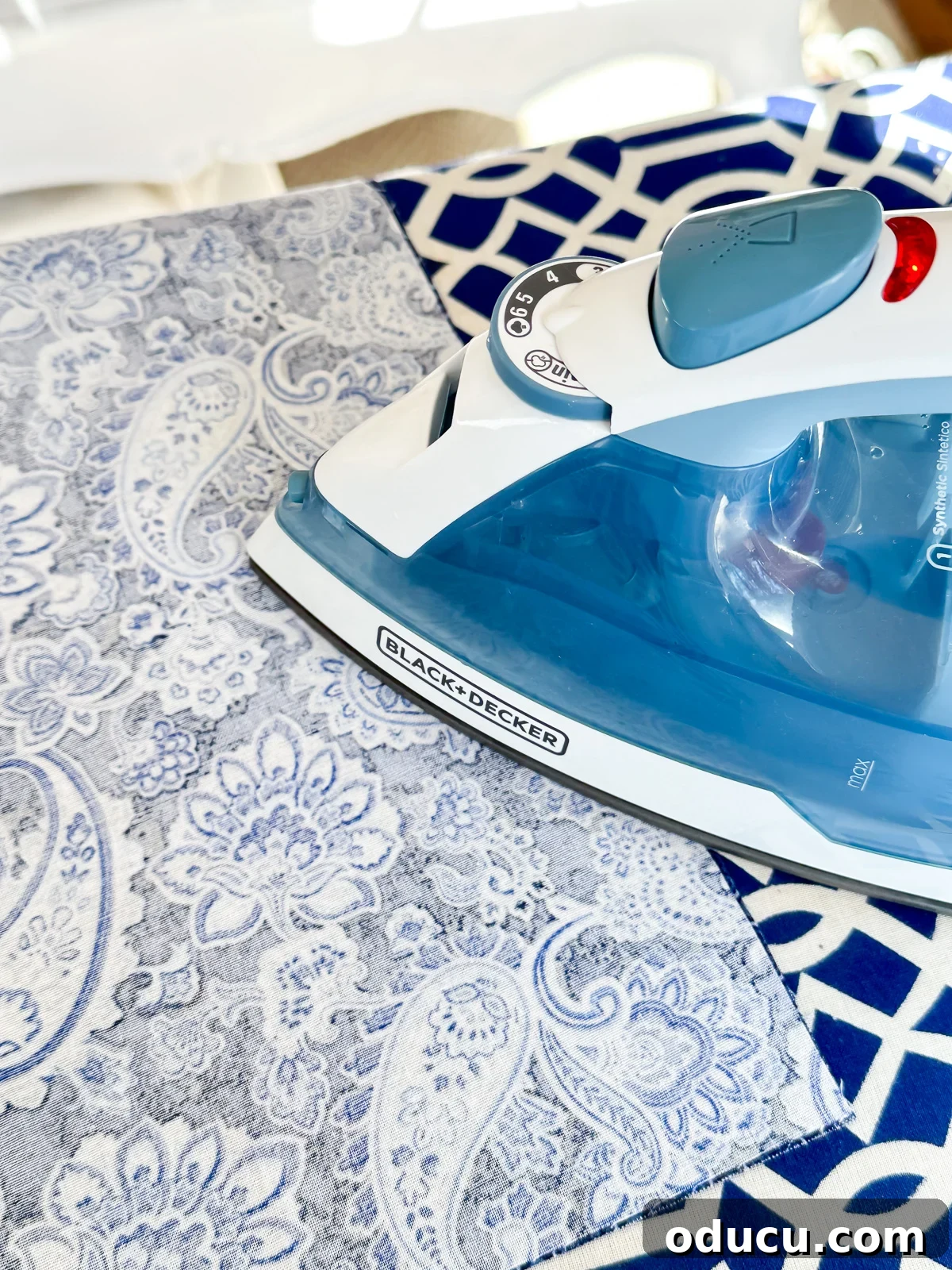 An iron pressing fabric that is being prepared to be made into a cloth napkin, ensuring a smooth surface for cutting and sewing.