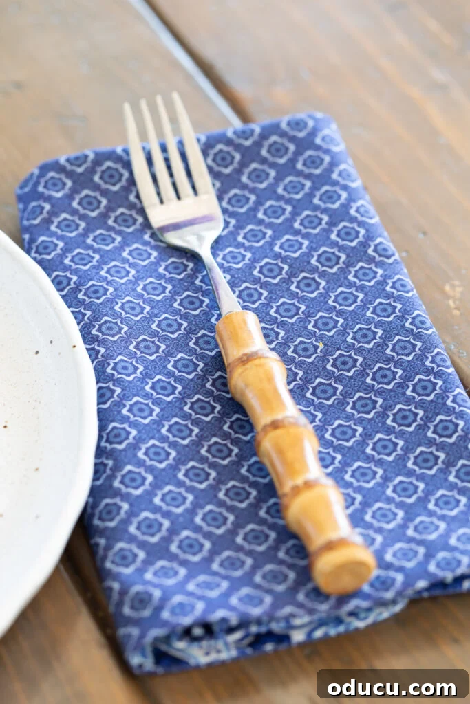 Whip Up Wonderful Napkins: A Simple Guide to Colorful Table Decor 6 A blue and white patterned fabric transformed into a luncheon-sized napkin, with a fork resting on top.