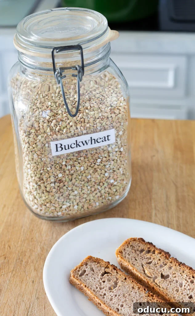 Buckwheat Toast Your Deliciously Wholesome Go To Snack 2 A glass jar filled with raw, hulled buckwheat groats and two slices of homemade buckwheat bread on a plate, ready for a healthy snack.