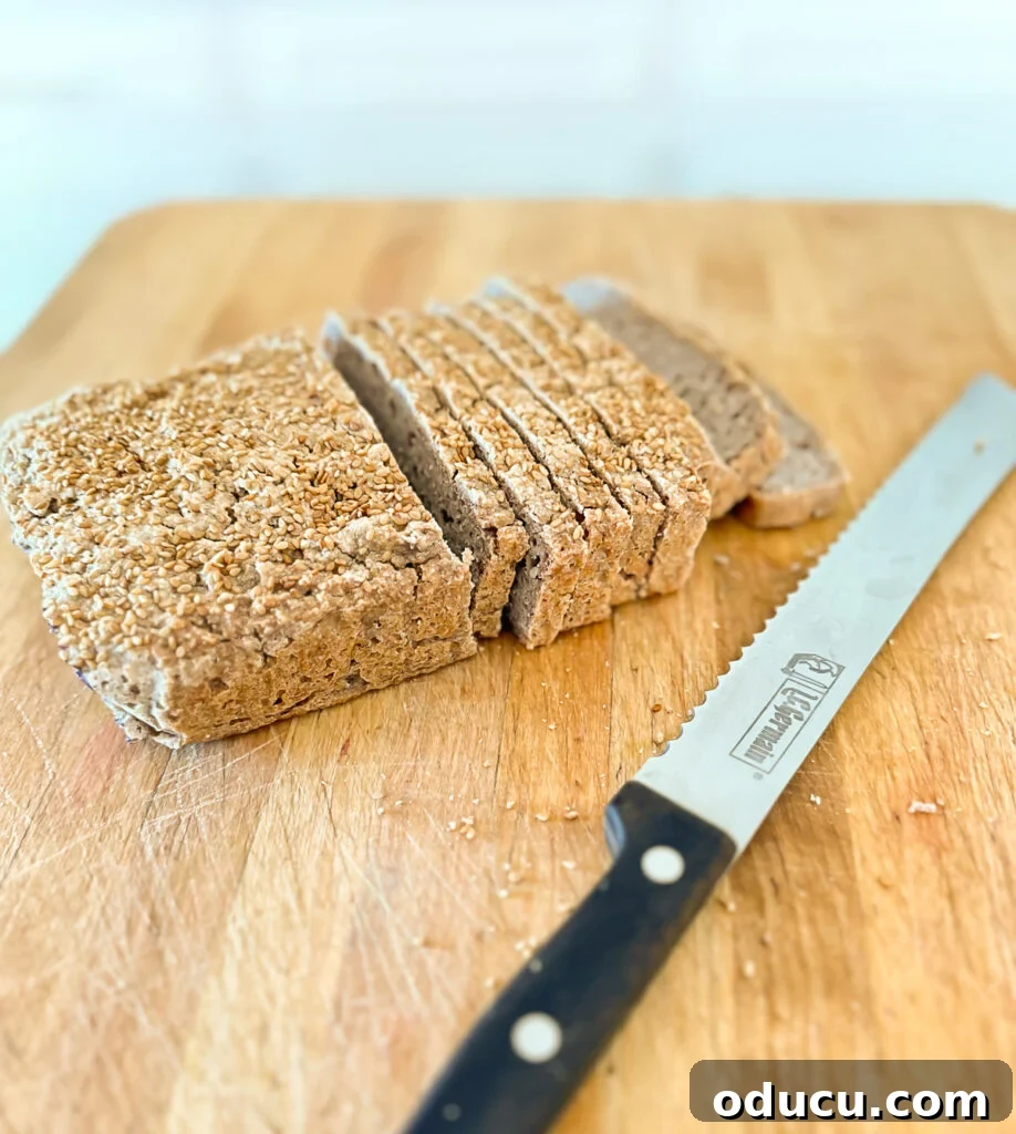 Buckwheat Toast Your Deliciously Wholesome Go To Snack 7 Freshly sliced 3-ingredient buckwheat bread arranged on a wooden cutting board with a bread knife.