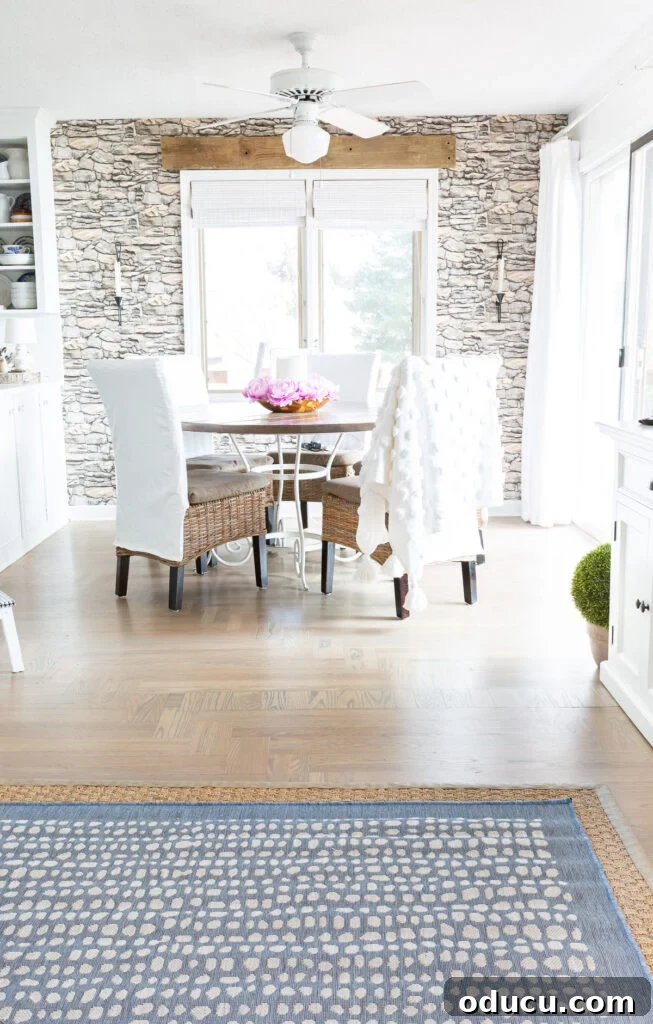 Elevating My Living Room with Area Rugs 2 Blue layered rug in a modern coastal living room, transitioning into a dining area.