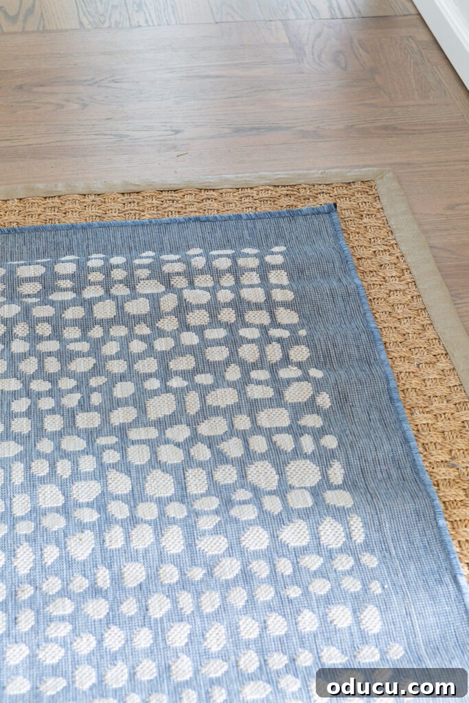 Elevating My Living Room with Area Rugs 8 Two area rugs layered one on top of the other, showcasing the seagrass rug beneath a new blue patterned rug.