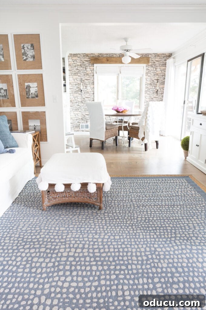 Elevating My Living Room with Area Rugs 9 Newly layered blue and white rug in a living room, viewed towards the dining area, enhancing the modern coastal theme.