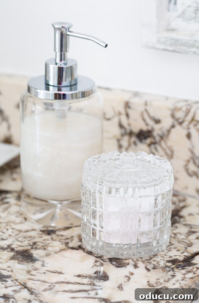 Primary Bathroom Sanctuary Unveiled 21 glass soap dispenser and cut crystal jar on bathroom cabinet.