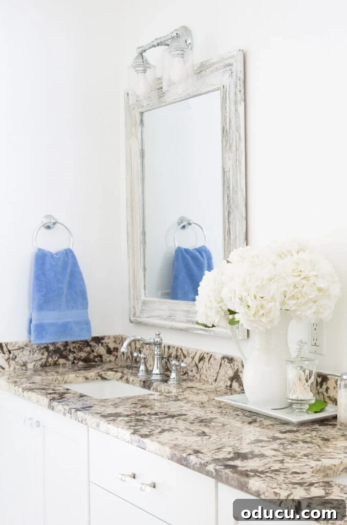 Unconventional Furniture Finishes Beyond Paint or Stain 2 sky blue towels in towel ring in neutral color bathroom.