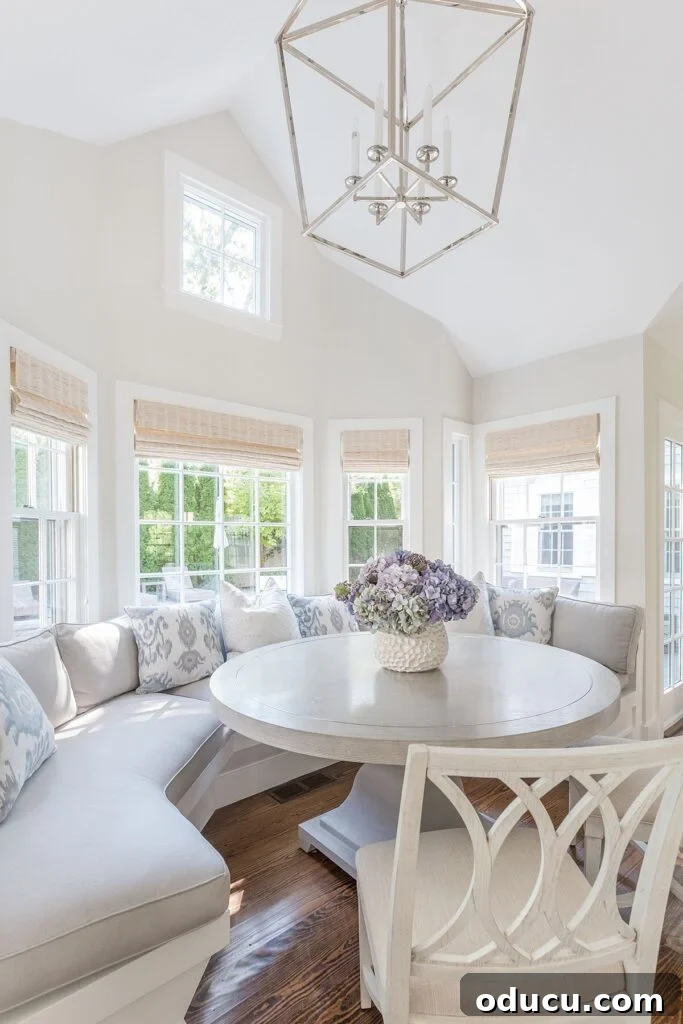 Fashion Discoveries 196 2 Elegant kitchen with a large, inviting round banquette in soft pale blue, complemented by white cabinetry and warm beige accents.