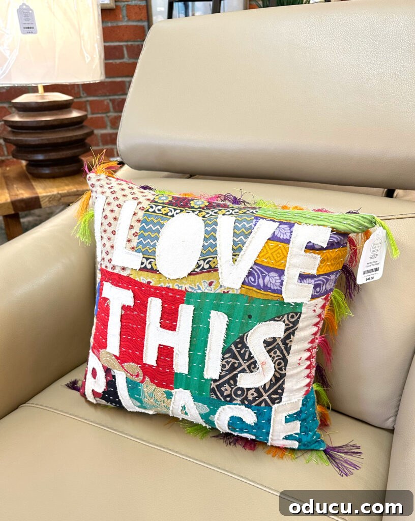 The Blissful Art of Home Embellishment 2 A charming throw pillow with the phrase 'I love this place' resting on a comfortable armchair, embodying personalized home decor.