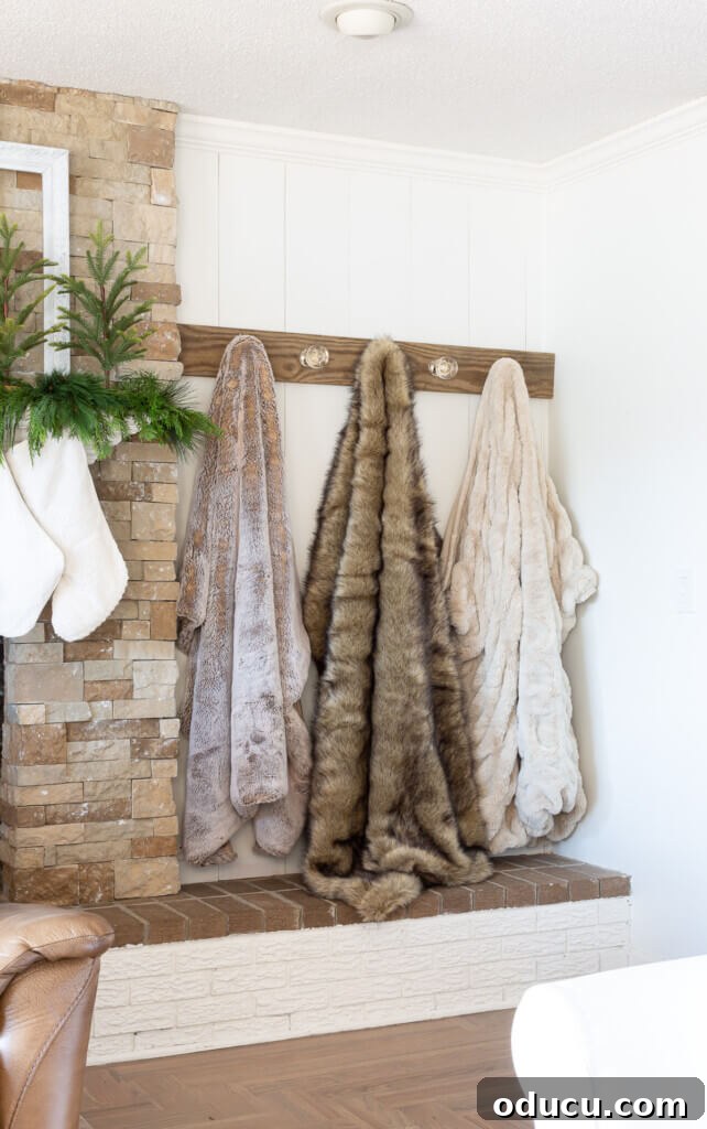 The Ever-Evolving Hearth 10 3 fur throw blankets hung on a wall mounted blanket holder.