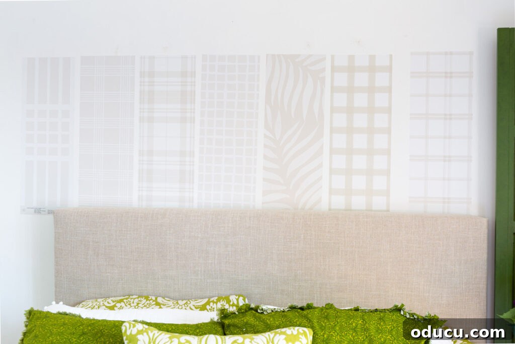 Chic Comfort for Guest Room One 10 Sampling-Love-&-Design-wallpapers-on-wall. Multiple beige wallpaper samples from Love vs. Design on a wall, showcasing neutral patterns.