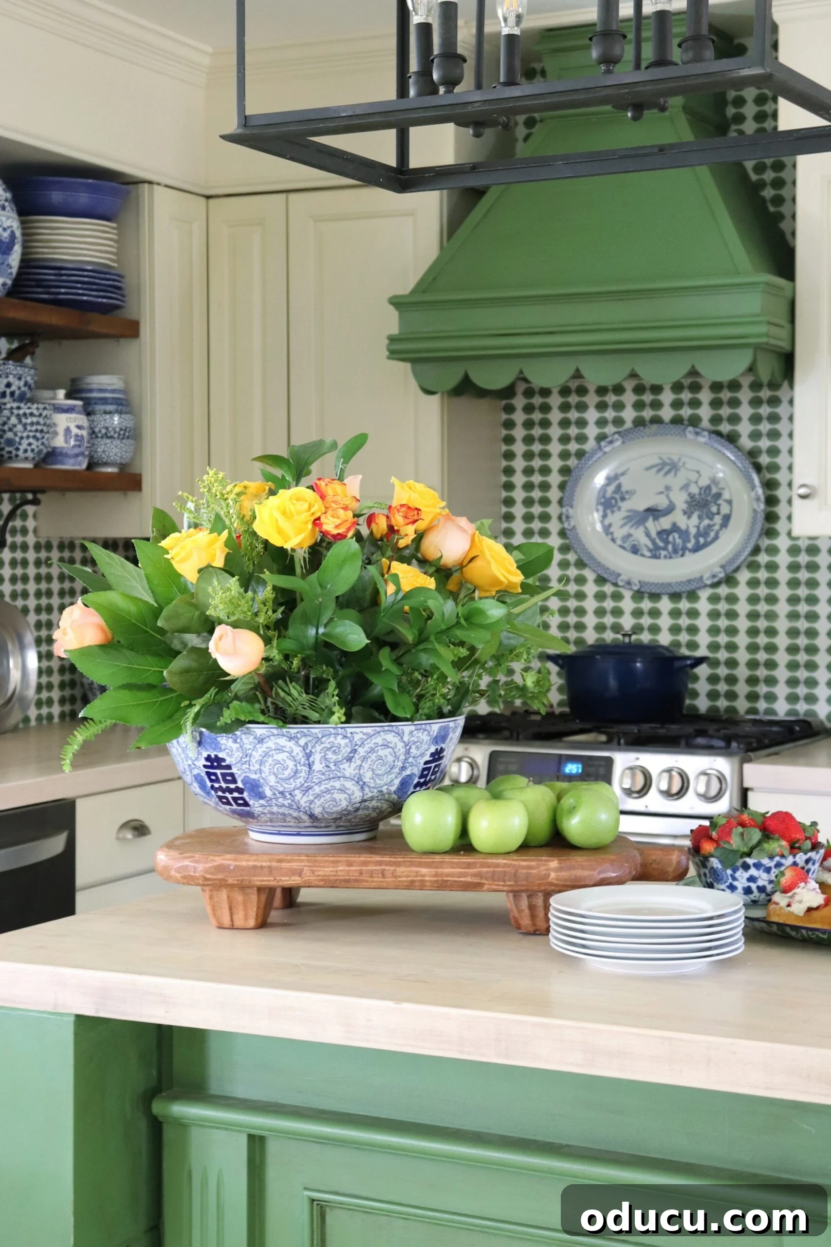 Style Expedition 2 Green and white kitchen with blue accents. A beautifully styled kitchen featuring olive green lower cabinets, crisp white upper cabinets, and vibrant blue decorative elements, creating a serene yet lively atmosphere perfect for family gatherings and culinary creativity.