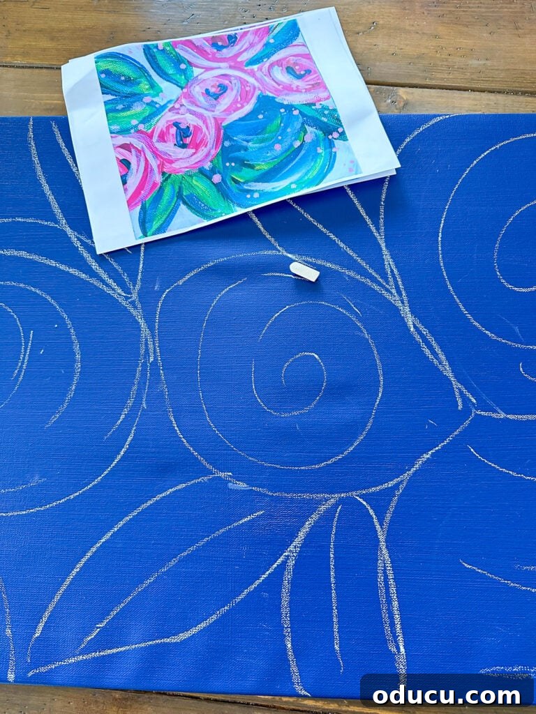Paint Your Own Canvas: Simple Art for Everyone 8 sketching blue painted art canvas with white chalk to draw flowers and leaves