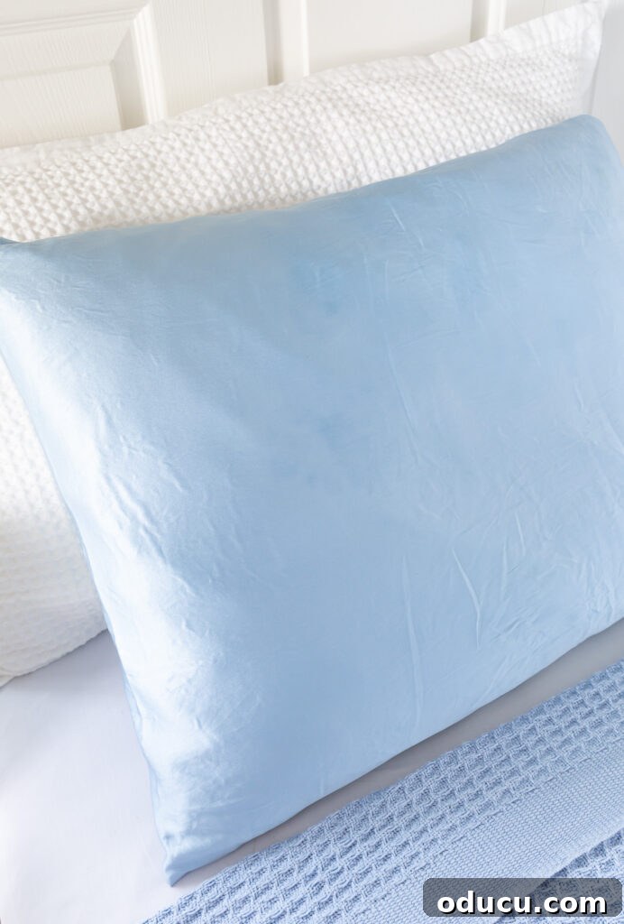 Hold Off on Fall Decorating Try This Alternative 25 Light blue silk pillowcase on a bed.