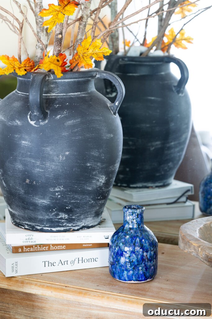 Cozy Autumn Vibes: Living Room Refresh 11 close up of a small blue crackle painted vase on a wood console table.