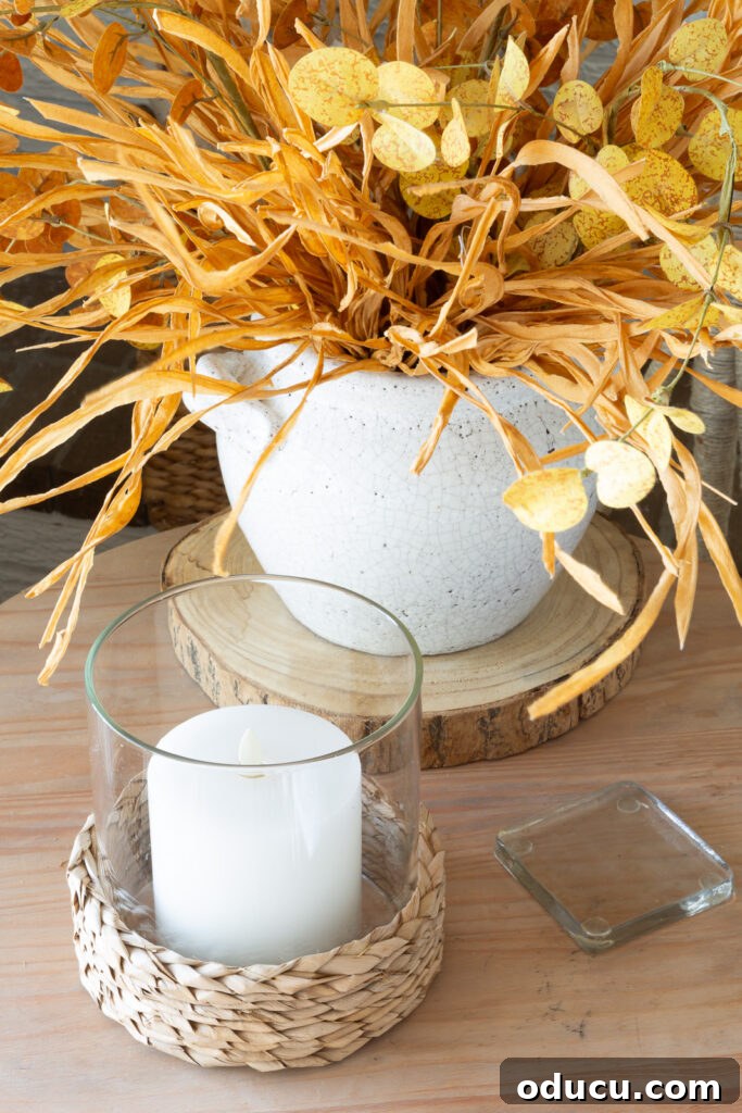 Cozy Autumn Vibes: Living Room Refresh 12 Wood side table with white candle and fall stems in a white crackled surface planter.