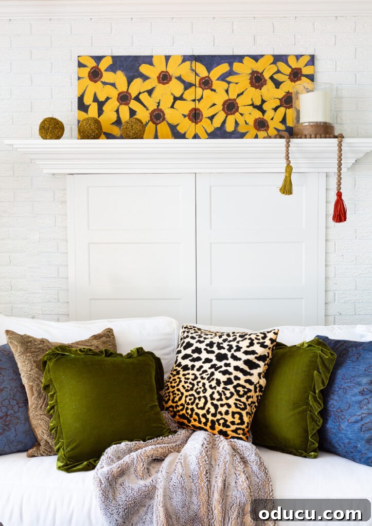 Cozy Autumn Vibes: Living Room Refresh 14 simple fall decor on a fireplace mantel in a white room with blue, green and burnt yellow accents.