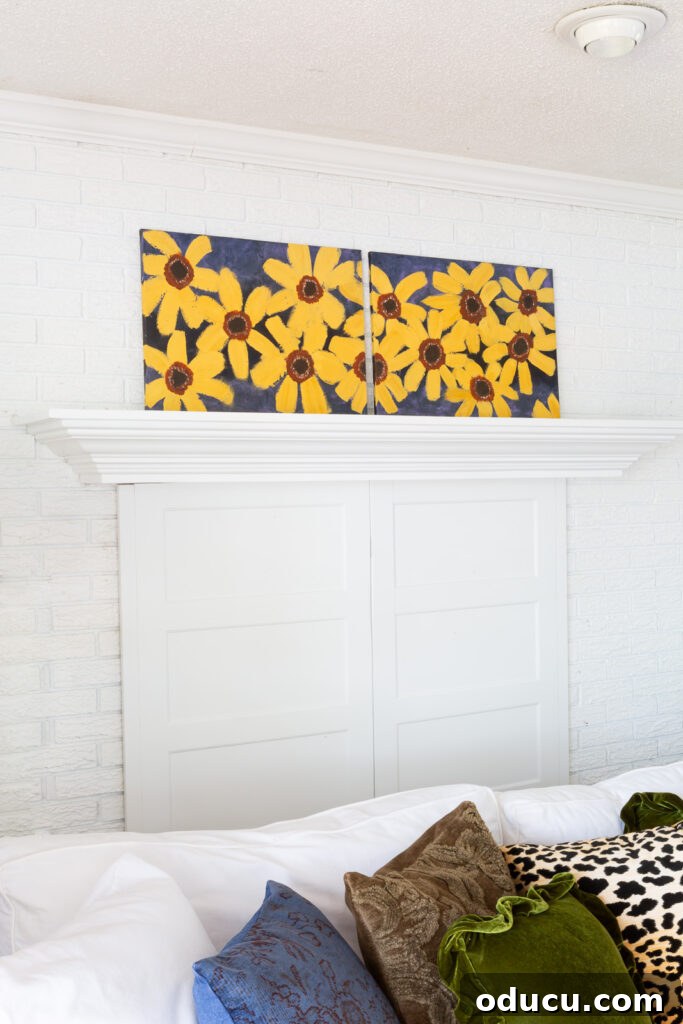 Cozy Autumn Vibes: Living Room Refresh 7 Painted fall flowers on a canvas leaning on a white fireplace mantel.