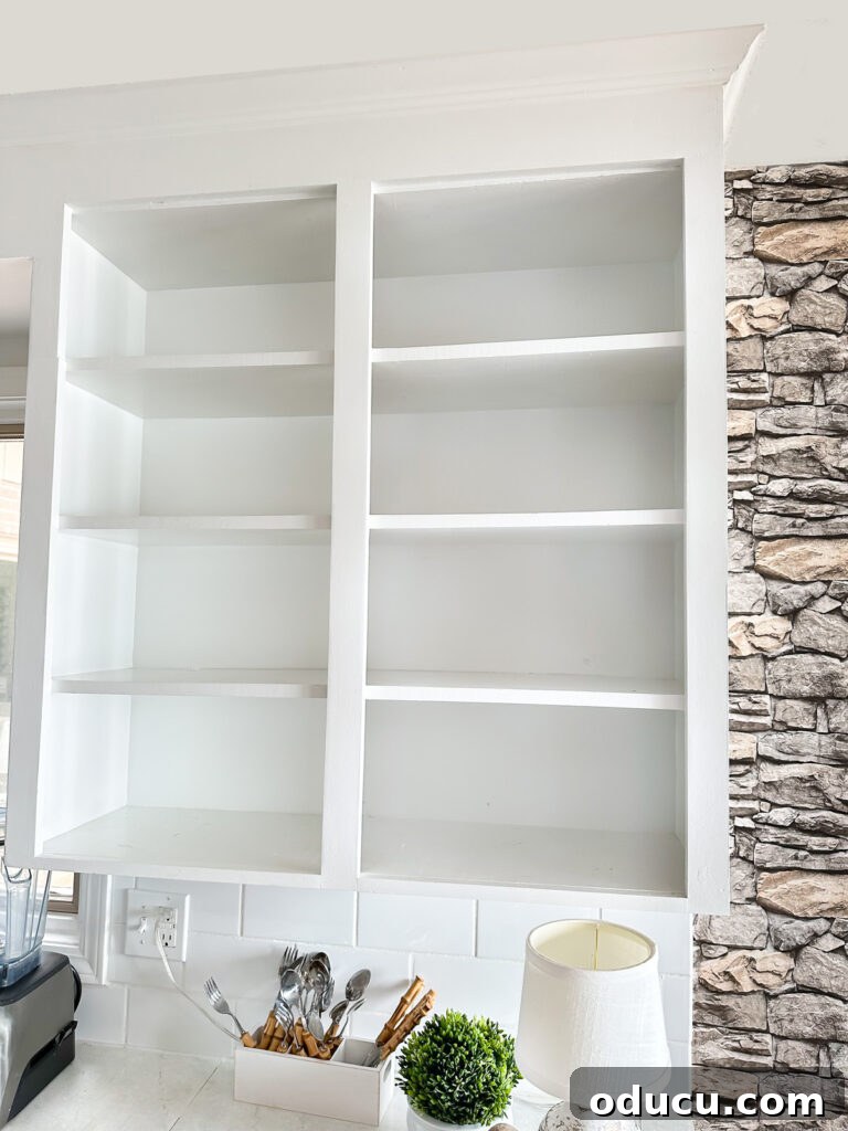 Fall Kitchen Shelves Get a Wallpaper Makeover 2 empty open shelves in white kitchen