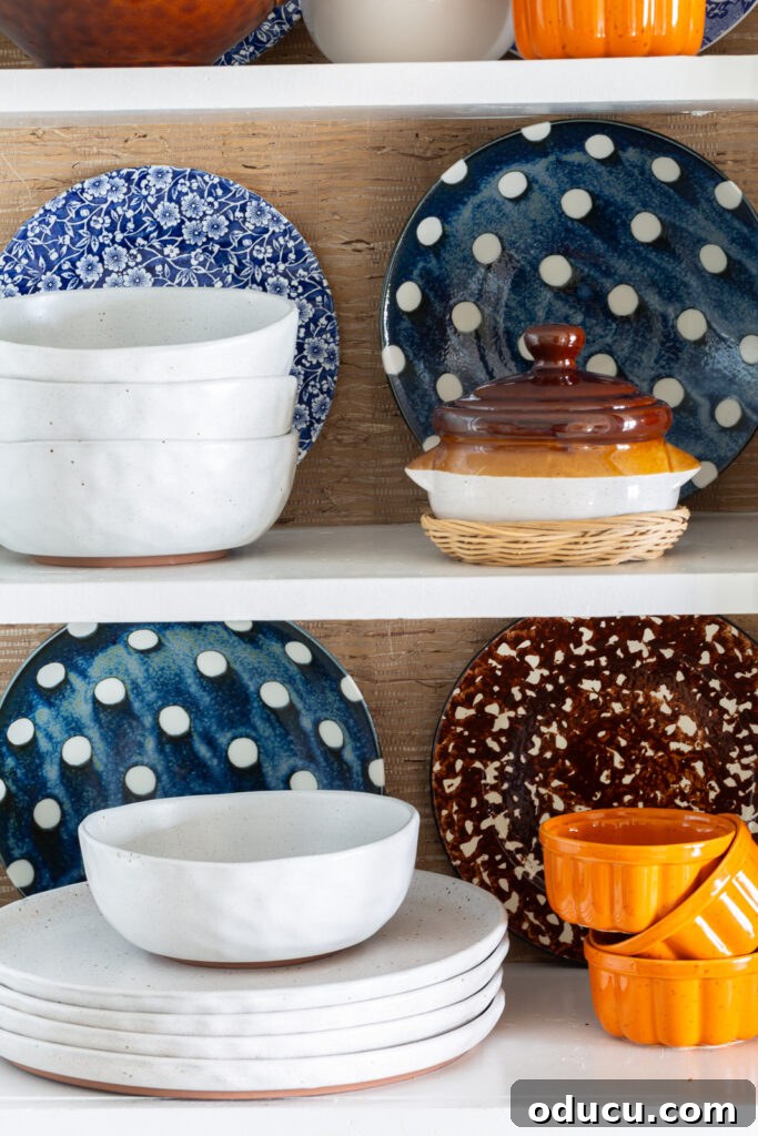 Fall Kitchen Shelves Get a Wallpaper Makeover 8 Fall colored kitchen items displayed on open shelves in a small kitchen decorated for fall.