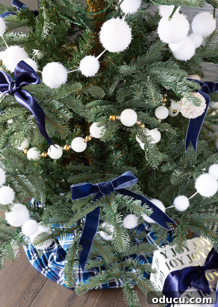 The King of My Christmas 14 White snowball garland and blue bows on Christmas tree.