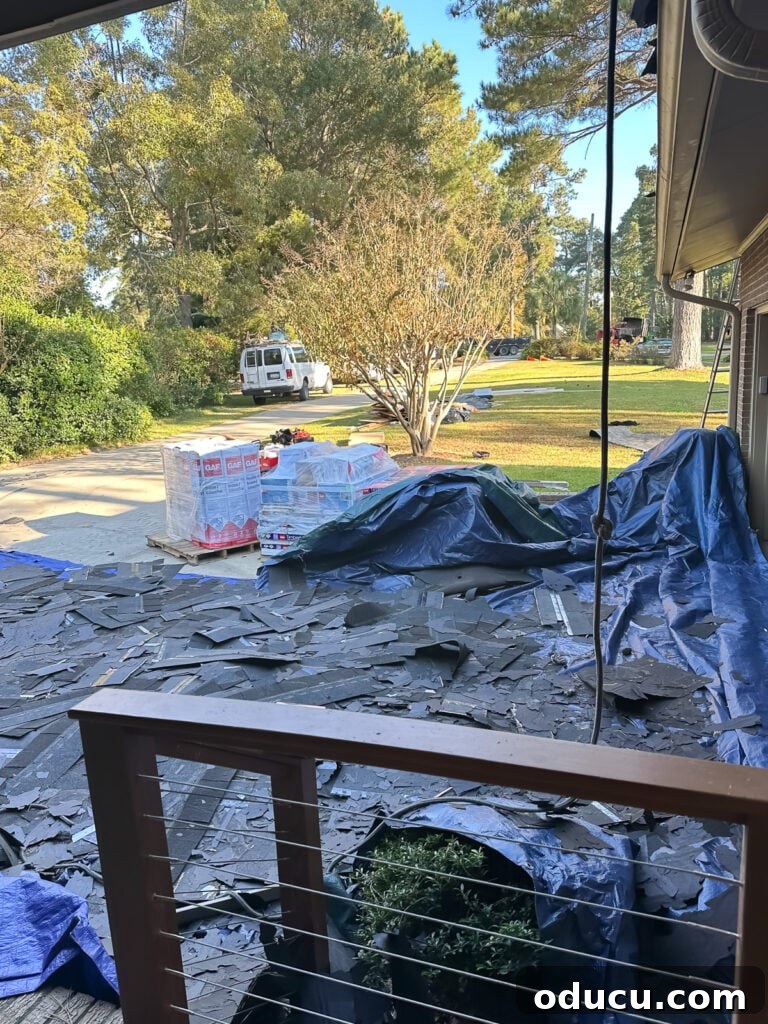 Adventures in Life and Home 5 Roofing crew removing old shingles and debris from the damaged roof of a house after a hurricane.