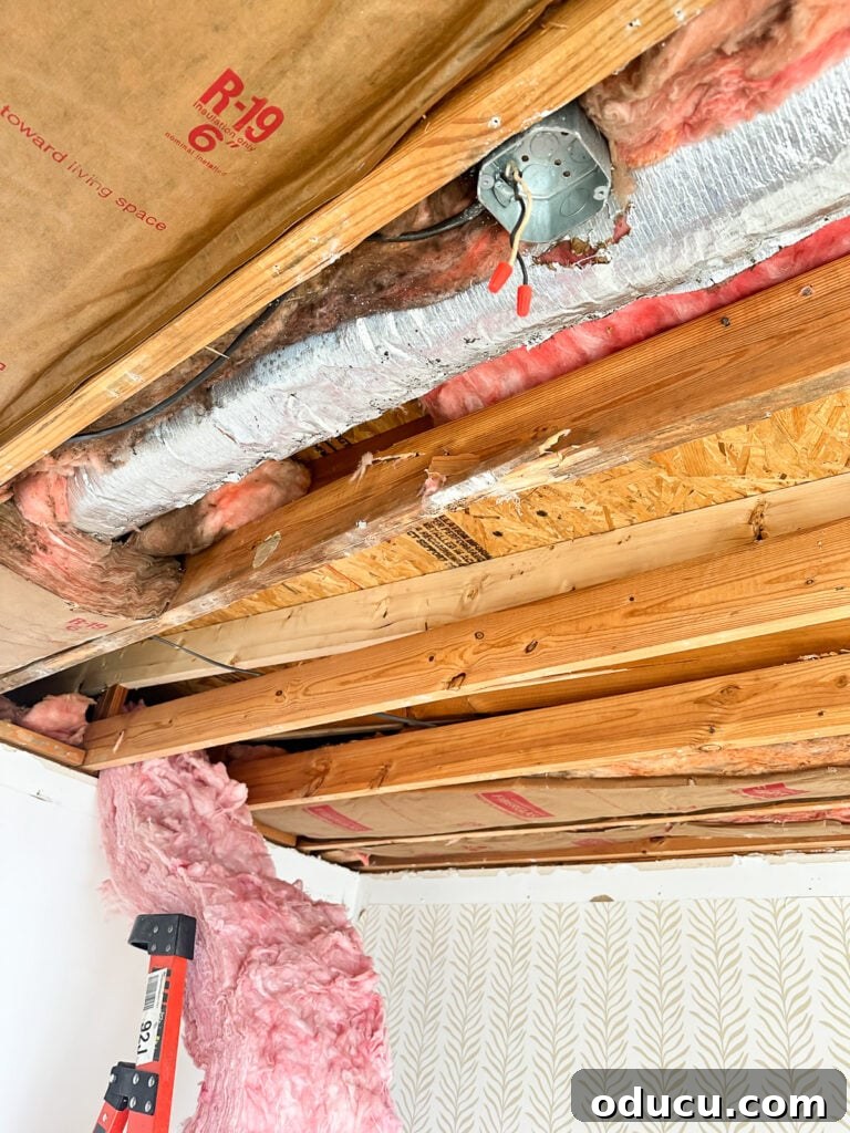Adventures in Life and Home 9 Interior view of a damaged guest room ceiling, showing exposed rafters and a new beam after structural repairs.