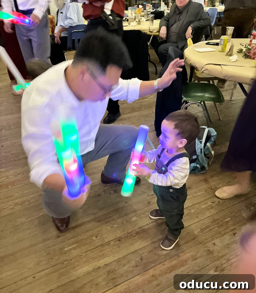 Mandy Ties the Knot 25 Dad and toddler son dancing with glow sticks at wedding