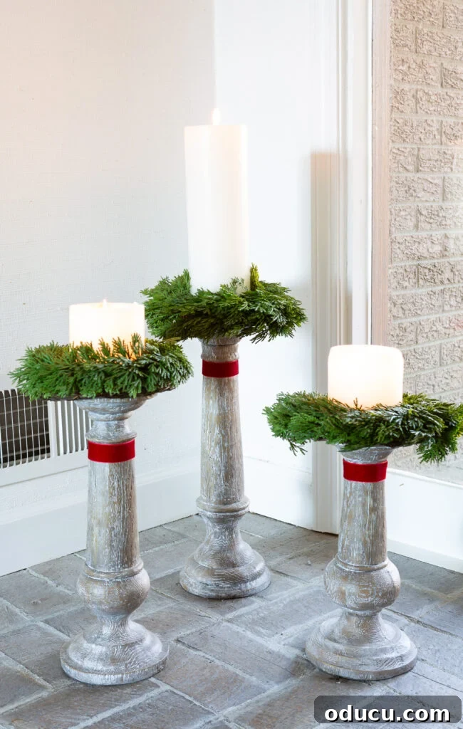 Decking the Halls for the Holidays 16 trio of large wood candle holders on floor with a wreath and red ribbon.