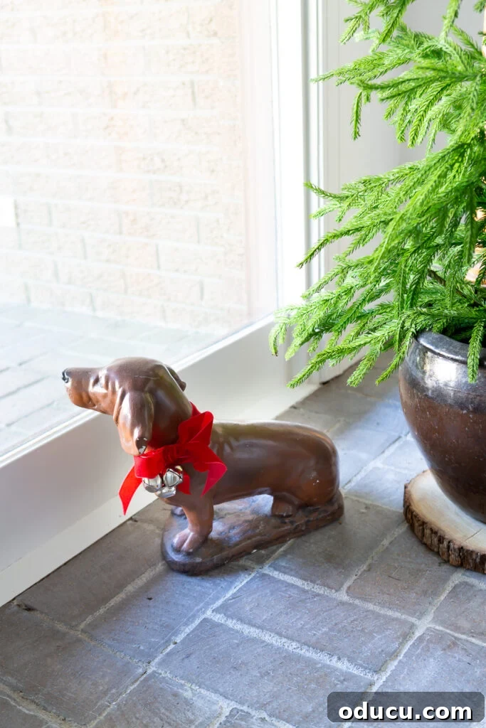 Decking the Halls for the Holidays 17 Dog statue with a red bow and jingle bells around his neck.