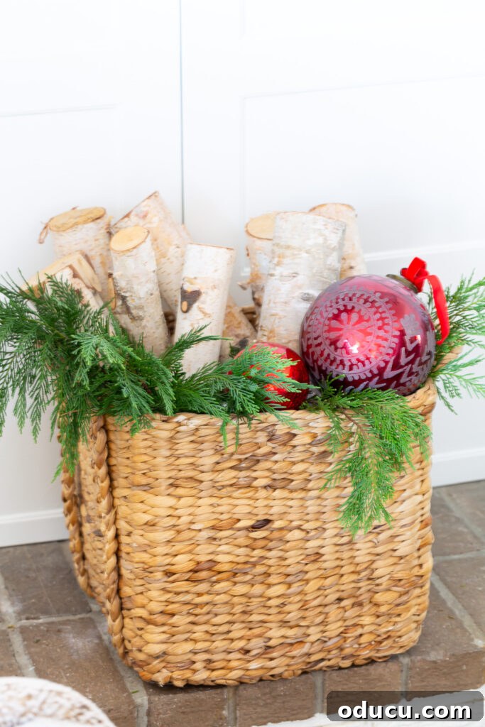 Decking the Halls for the Holidays 3 Basket filled with firewood, greenery and red Christmas ornaments.
