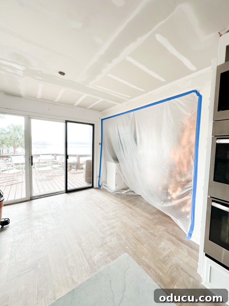 My Kitchen's Stunning Spacious Makeover 2 Living room seen through plastic sheeting during kitchen and ceiling renovation, protecting it from sanding dust.