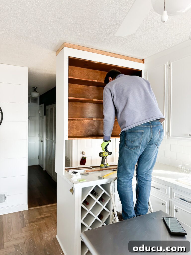 My Kitchen's Stunning Spacious Makeover 4 Demonstration of how to remove a group of old kitchen cabinets attached to both the wall and ceiling.