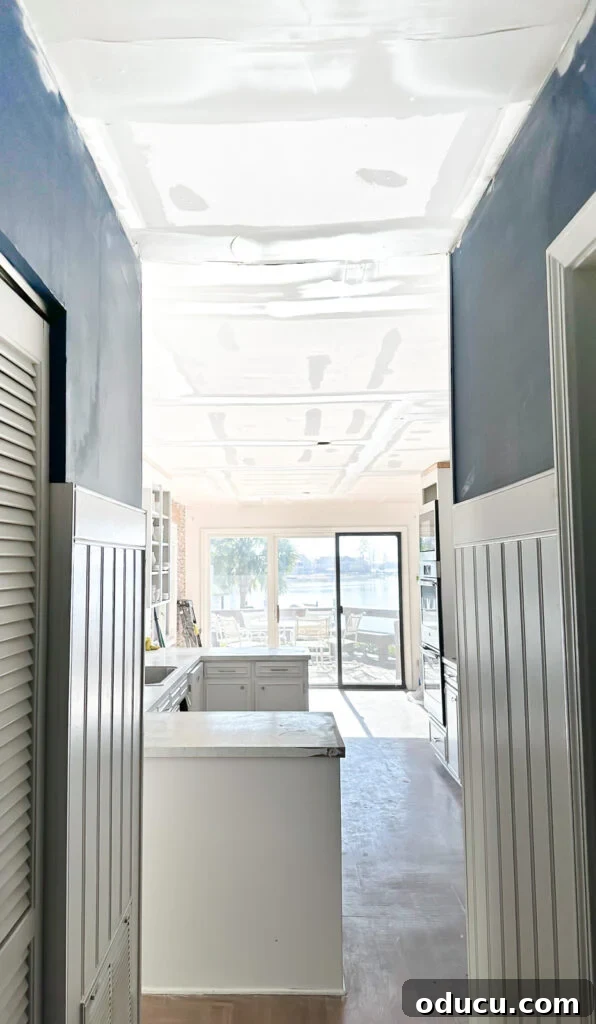 My Kitchen's Stunning Spacious Makeover 10 View from hallway into kitchen after popcorn ceiling removal, showcasing improved light and open space.