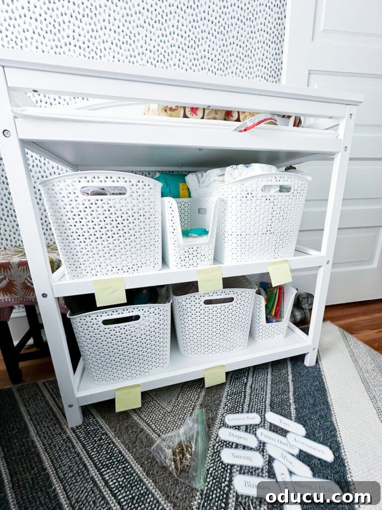Elevate Your Nursery: Printable Basket Labels for Stylish Organization 5 Custom blue and white nursery labels laid out on the floor, ready to be attached to storage baskets